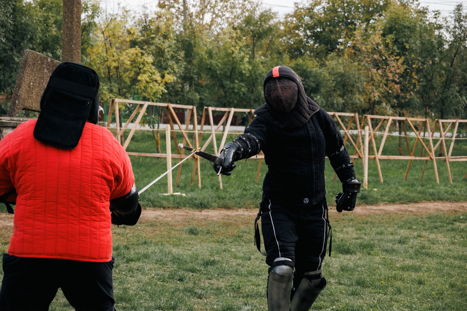 Two fencers in protective kit during controlled sparring