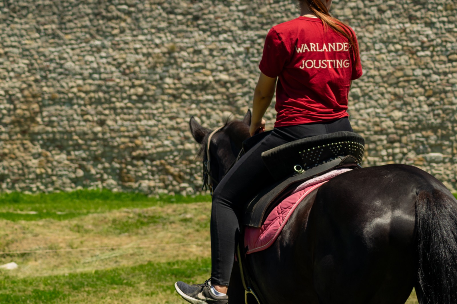 A Warlander rider seated in the saddle on a black horse