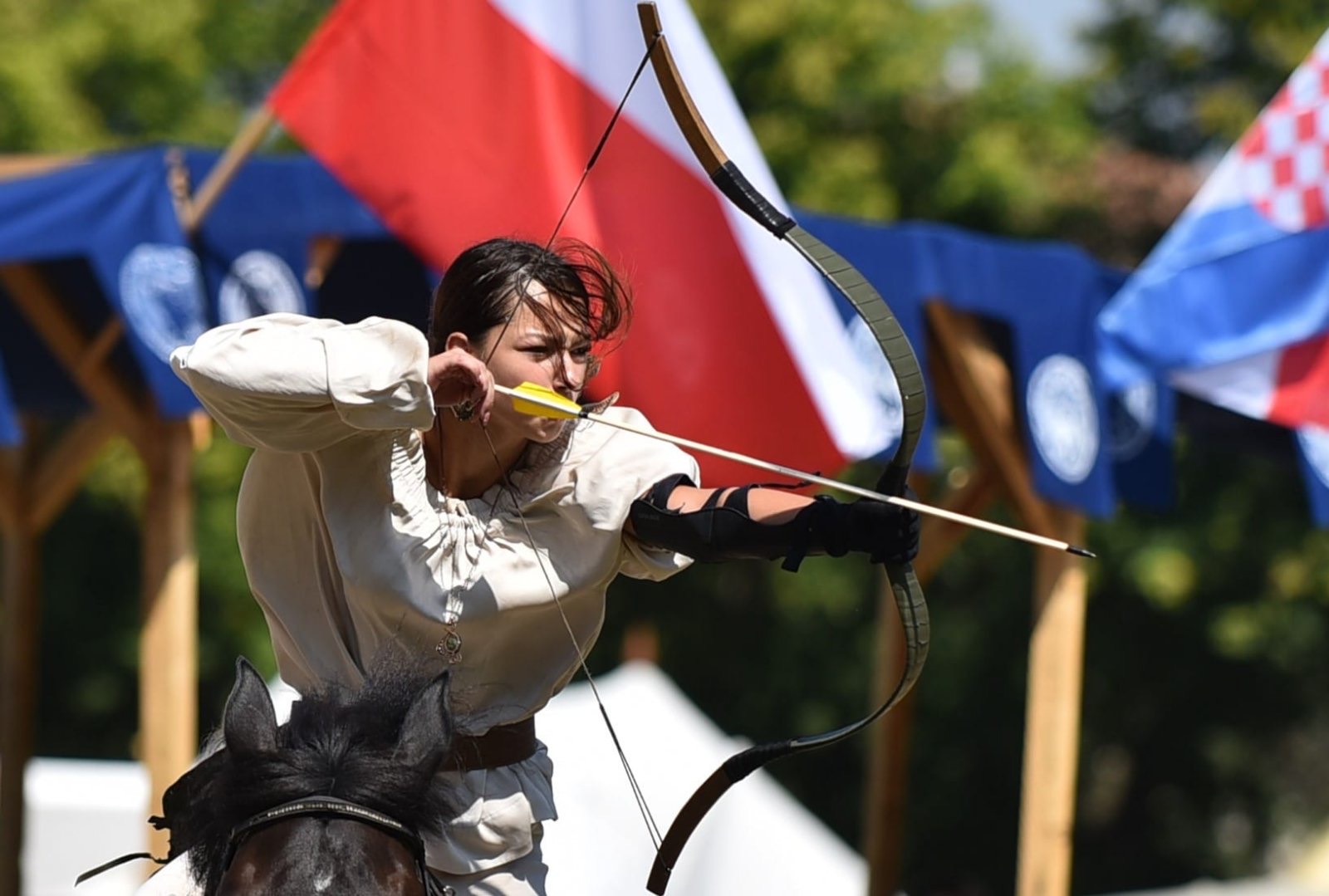 A horseback archer at full draw, the arrow resting along the bow