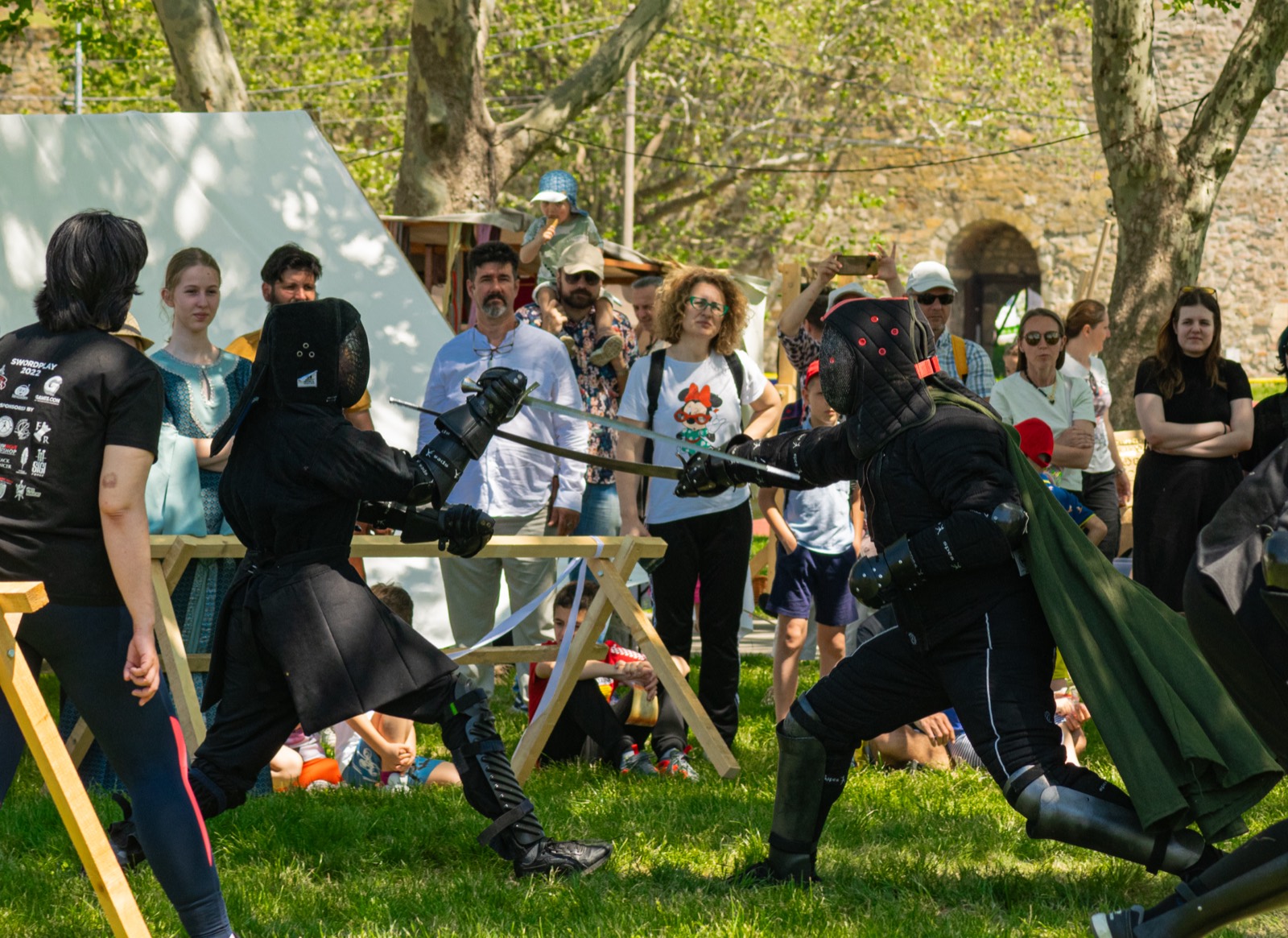 Fencers exchanging blows before a crowd at a Warlander tournament